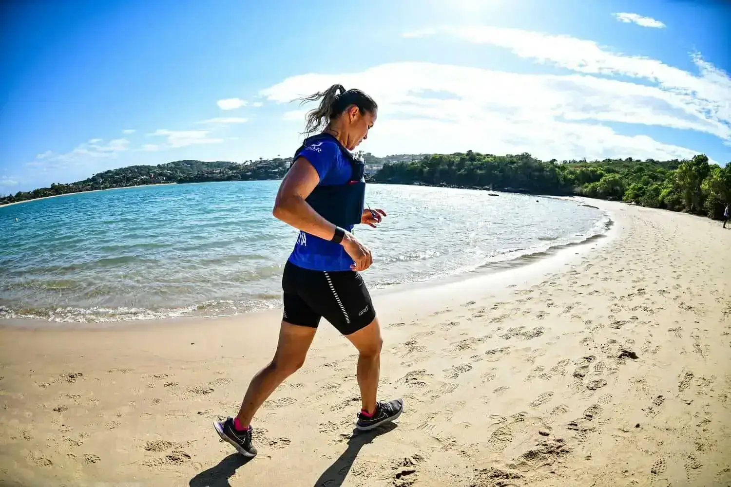 Mulher da equipe vn trainer correndo na praia