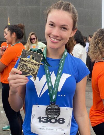 corredora da equipe vn trainer com a medalha da corrida Meia Maratona do Cristo