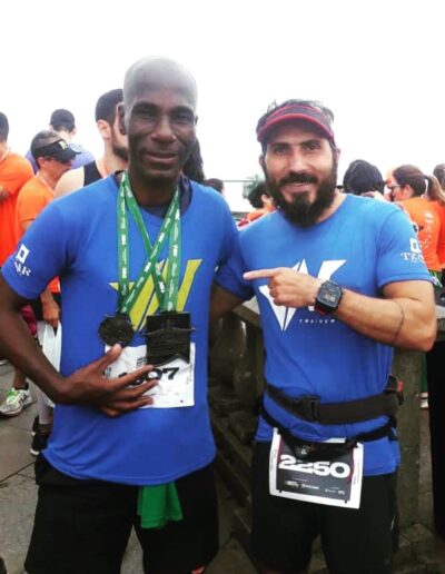 dois corredores da vn trainer com camisas azuis da equipe que correram a Meia Maratona do Cristo